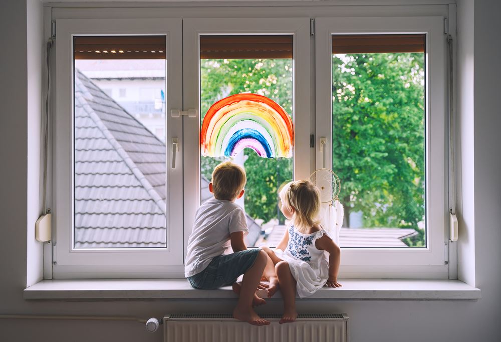 Two children looking outside a window